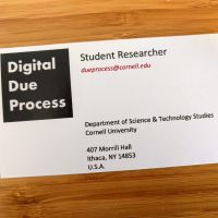 A photo of a business card for student researchers at the Digital Due Process Clinic, showing the clinic logo and contact data
