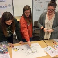 Three undergraduate student members of the STS Futures Lab collaborate on a design fiction prototype as part of the Co-Imagining Futures workshop