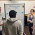 Undergraduate student members of the STS Futures Lab stand at a whiteboard as they collaborate on a scenario analysis related to implementation precision medicine