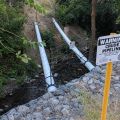 Crude oil pipe running exposed over a creek leading into downtown Salt Lake City, Utah, US